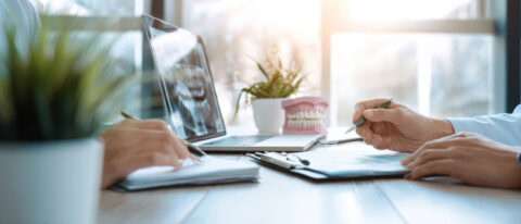The dental consultation with hands discussing treatment and technology in a modern setting.